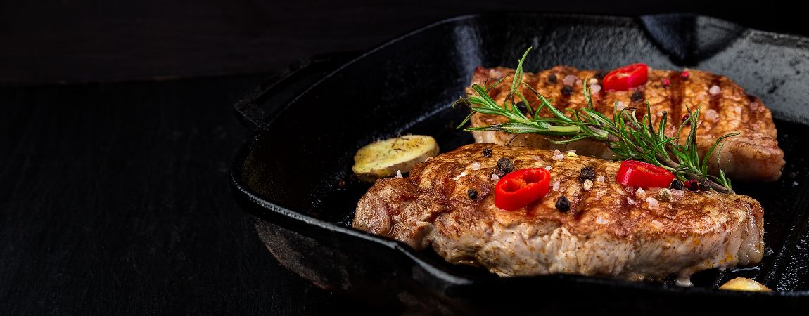 Kawałki mięsa na żeliwnej patelni