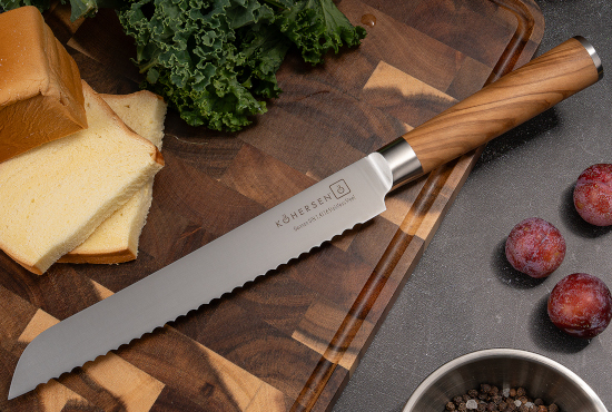 zdjęcie noża do chleba Kohersen Essence Olive Wood na desce do krojenia
